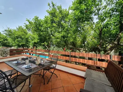 a patio with a table and chairs and trees at Apartment Edera di Patrizia by Interhome in Castellammare del Golfo