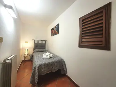 a bedroom with a bed with a table with towels on it at Apartment Edera di Patrizia by Interhome in Castellammare del Golfo