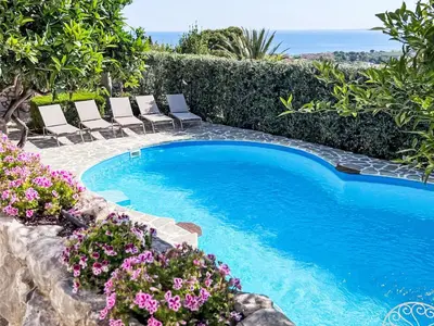 a swimming pool with lounge chairs and flowers at Apartment Edera di Patrizia by Interhome in Castellammare del Golfo
