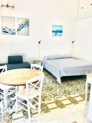 a bedroom with a bed and a table and chairs at Casa Colore Loft in Castellammare del Golfo