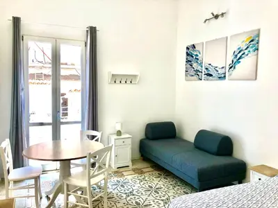 a bedroom with a blue couch and a table at Casa Colore Loft in Castellammare del Golfo