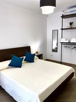a bedroom with a large bed with blue pillows at Quattro Canti al Cassaro in Palermo