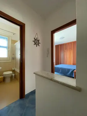 a bedroom with a bed and a bathroom with a counter at NEREA - Appartamento fronte mare in San Vito lo Capo