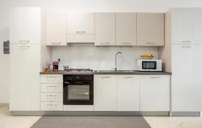 a kitchen with white cabinets and a microwave at Beautiful Apartment In Balestrate in Balestrate
