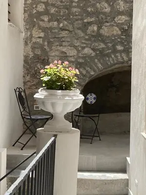 a vase with flowers sitting on top of a wall at Patio1861 - A Sicilian deluxe apartment in Termini Imerese