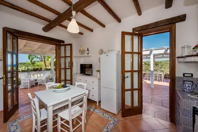 a kitchen and dining room with a table and chairs at NUOVA Villa Intera Guidaloca in Scopello