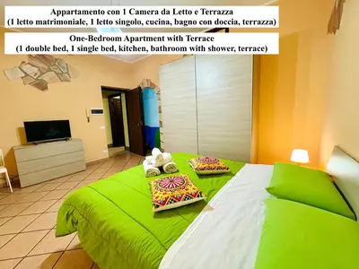 a green bed with two pillows on top of it at Le Maioliche in Sferracavallo