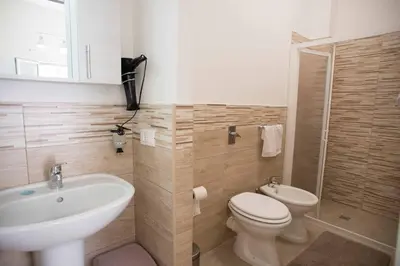 a bathroom with a white sink and a toilet at Isola bella in Isola delle Femmine