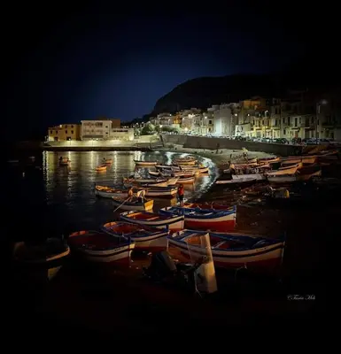 a group of boats sitting in the water at night at I TRAMONTI D'ASPRA in Bagheria