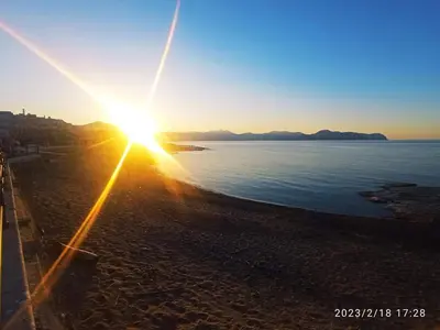 a sunset on a beach with the sun setting at I TRAMONTI D'ASPRA in Bagheria