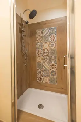 a shower with a tile wall in a bathroom at La casetta di Maria alla Ciba in Termini Imerese