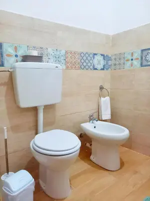a bathroom with a white toilet and a sink at Le notti di Nettuno a Isola Delle Femmine in Isola delle Femmine