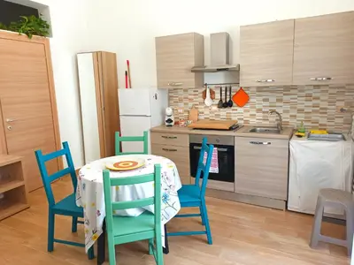 a kitchen with a table and chairs in a kitchen at Le notti di Nettuno a Isola Delle Femmine in Isola delle Femmine