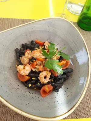 a bowl of food with shrimp and black beans at Residenza sabbia dorata in Alcamo