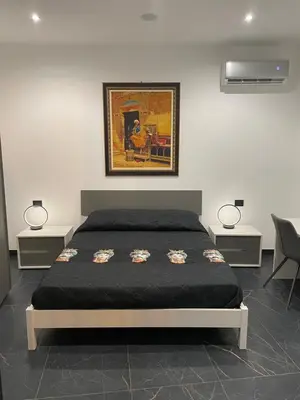a bedroom with a bed with two lamps and a painting at Case vacanze donna Ina in Palermo