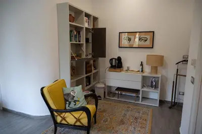 a living room with a yellow chair and a desk at Le Tartarughe di Ro' Casavacanze in Mondello