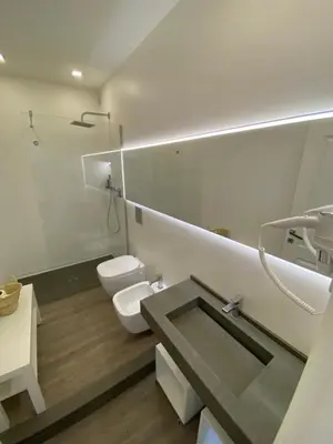 a bathroom with a sink and a toilet and a mirror at SuiteInPalermo - case vacanze nel centro storico in Palermo