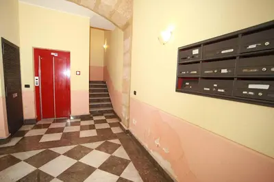 a hallway with a red door and a checkered floor at Appartamento con terrazza al centro storico. in Palermo