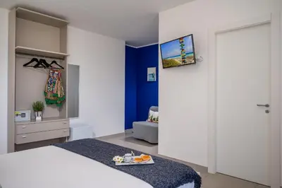 a bedroom with a bed and a tv on a wall at Villa Maria con piscina e vista mare in Castellammare del Golfo