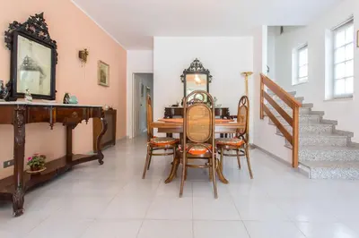 a dining room with a table and chairs and stairs at Independent Villa Located a few Minutes Walk From the Beach in Quiet Area in Palermo