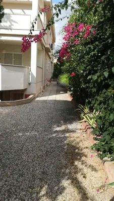 a sidewalk next to a building with pink flowers at Independent Villa Located a few Minutes Walk From the Beach in Quiet Area in Palermo