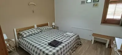 a bedroom with a bed with a checkered blanket at Flyhouse PARCHEGGIO AUTO BICI GRATUITO in Piana degli Albanesi