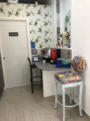 a kitchen with a counter and a stool and a door at MARINA BAY in Terrasini