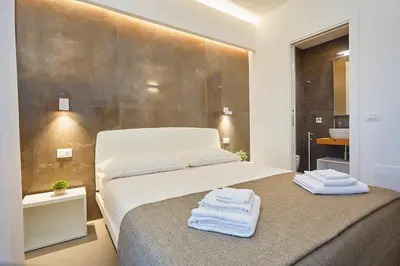 a bedroom with a bed with towels on it at Porta del Golfo Apartments & Suites in Castellammare del Golfo