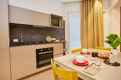 a kitchen with a table and a kitchen with a dining room at Porta del Golfo Apartments & Suites in Castellammare del Golfo