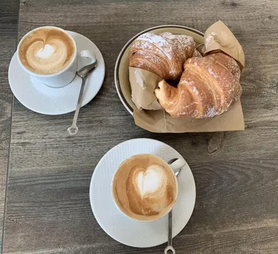 a table with two plates of pastries and a cup of coffee at Christian Guest House in Terrasini