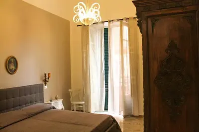 a bedroom with a bed and a window with a chandelier at A casa di Enza B&B in Palermo