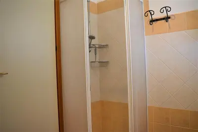 a shower with a glass door in a bathroom at Casa Bouganville in Scopello