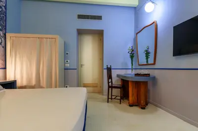 a bedroom with a bed and a table and a mirror at CELSO 14 in Palermo
