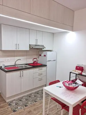 a kitchen with a table and a white refrigerator at Balsamotto - Appartamento e parcheggio in Palermo