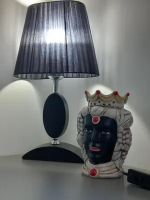 a lamp with a statue of a head with a crown at Momenti e Monumenti in Palermo