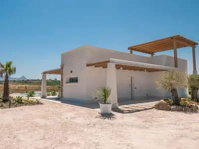 a house in the middle of a desert with palm trees at VILLA DELLA QUBBAH with pool in Alcamo