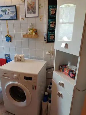 a laundry room with a washing machine and a refrigerator at Villa Maricetta in Castellammare del Golfo