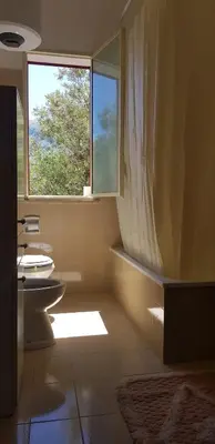 a bathroom with a tub and a sink and a window at Villa Andrea in Scopello