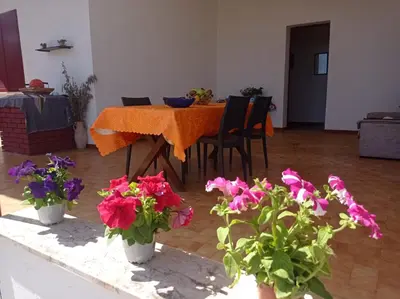 a dining room with a table and some flowers at Villa Andrea in Scopello