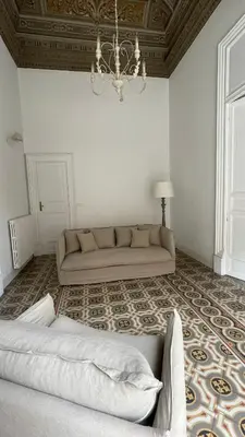 a living room with a couch and a chandelier at DonnaFrancaFlorio in Palermo