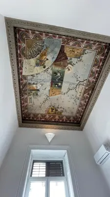 a painting on the ceiling of a room with a window at DonnaFrancaFlorio in Palermo