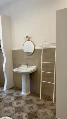 a bathroom with a sink and a mirror and a ladder at DonnaFrancaFlorio in Palermo