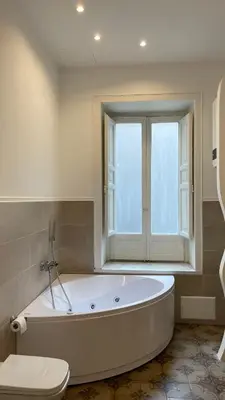 a large bath tub in a bathroom with a window at DonnaFrancaFlorio in Palermo