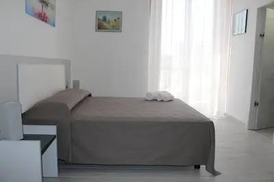 a bedroom with a bed in a white room at Rahal B&B in Palermo