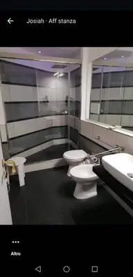 a bathroom with two toilets and a sink and mirrors at La Dimora del Massimo in Palermo