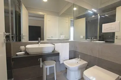 a bathroom with a sink and a toilet and a mirror at La Dimora del Massimo in Palermo