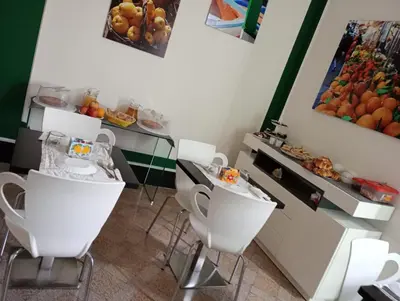 a room with white chairs and a counter with fruit at La Dimora del Massimo in Palermo