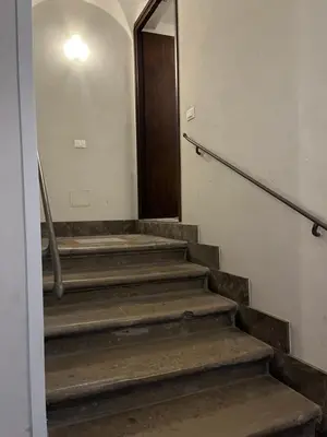 a hallway with stairs with a door and a mirror at Casa Kilò in Palermo