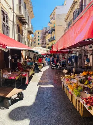 a market with fruits and vegetables on a street at Casa Kilò in Palermo