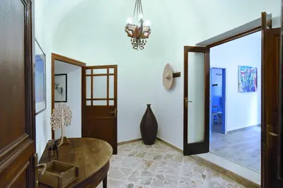 a hallway with a table and a mirror and a chandelier at Casa Azul in Terrasini